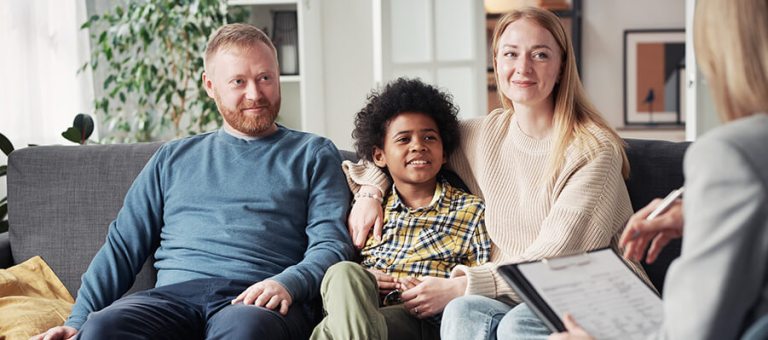 Smiling adoptive family meeting with social worker.