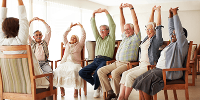 Daily stretching exercise routine for a group of cheerful elderly people at an old age home