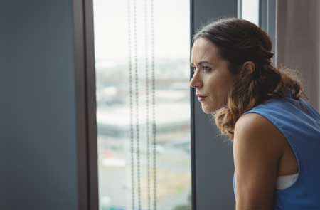 Woman in blue looking out window